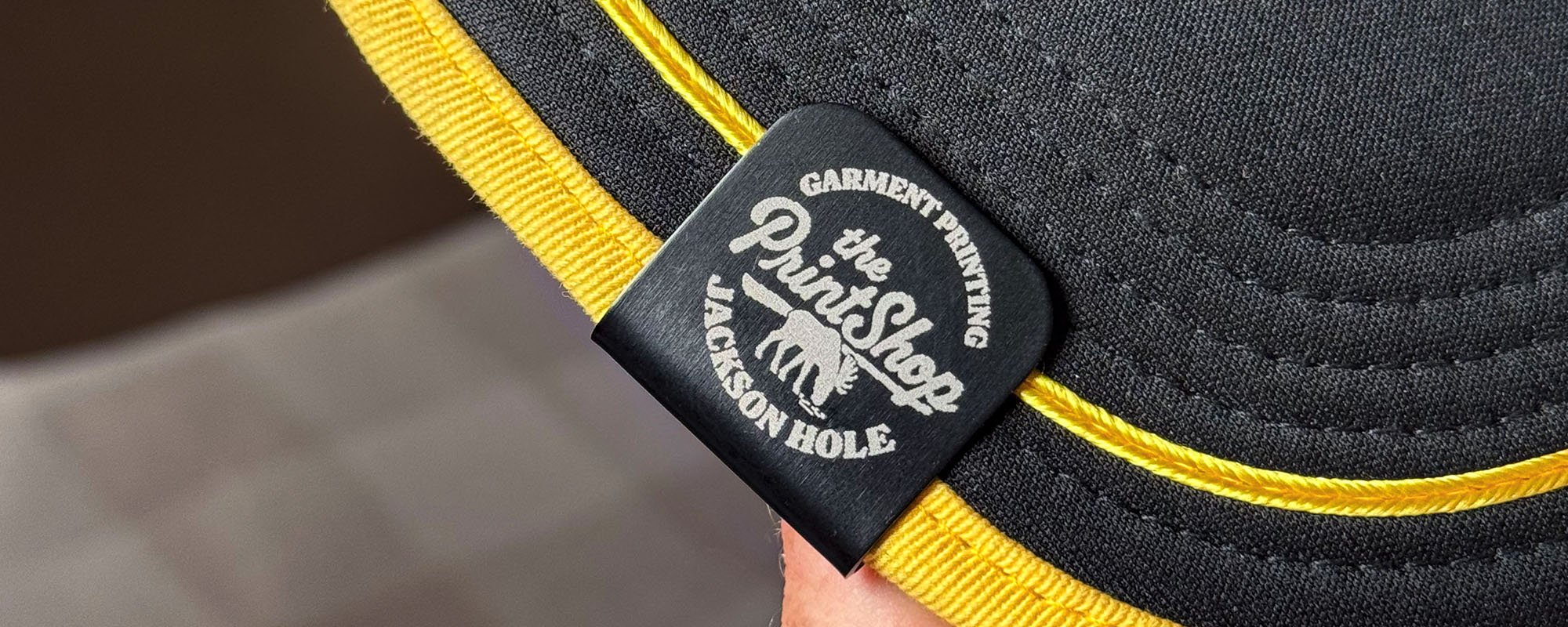 Laser engraved metal hat clips on a hat brim
